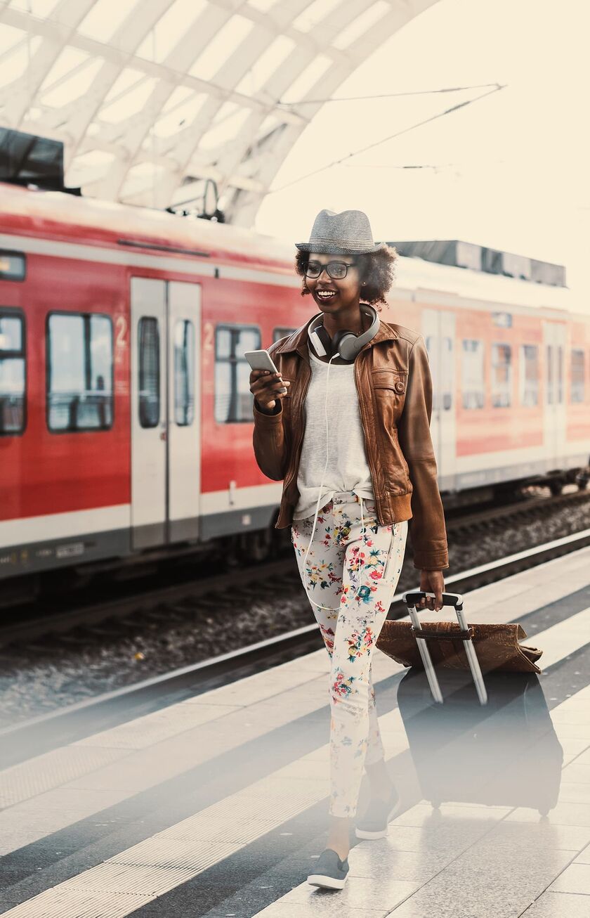En kvinde er lige stået af et tog og smiler