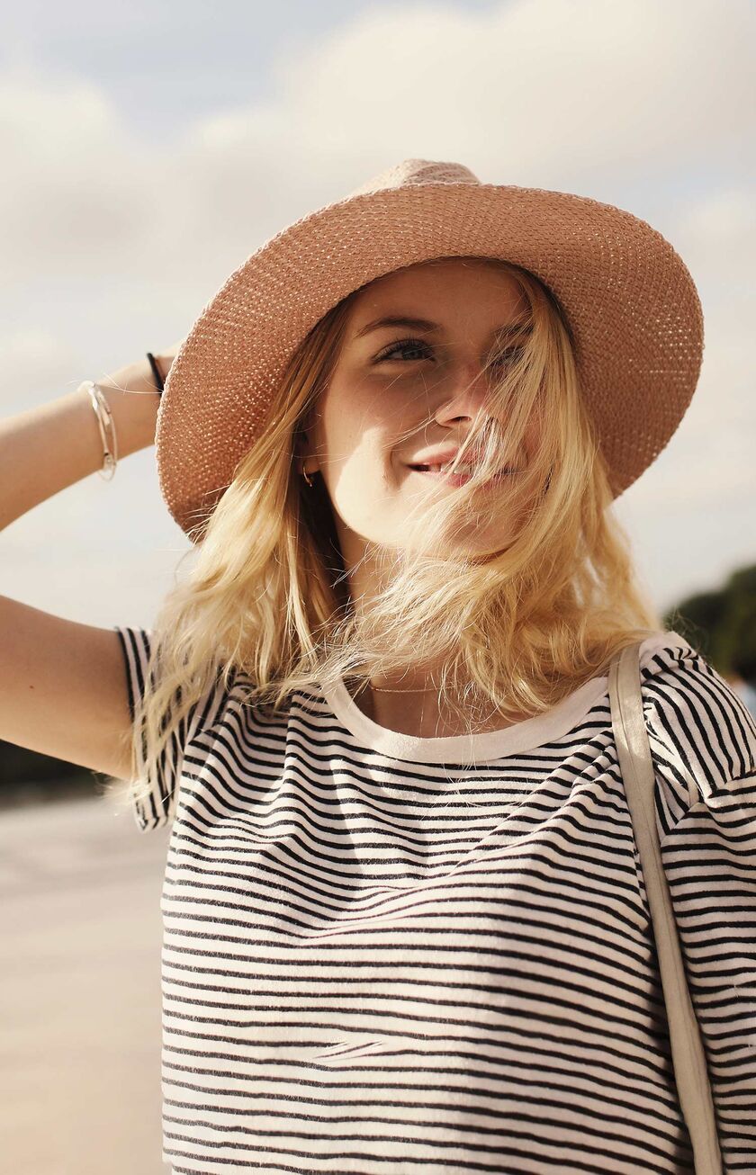 Mujer rubia con sombrero de paja sonriente