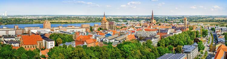 Vista de la ciudad de Rostock, en Alemania, con el cielo azul salpicado con algunas nubes de fondo.