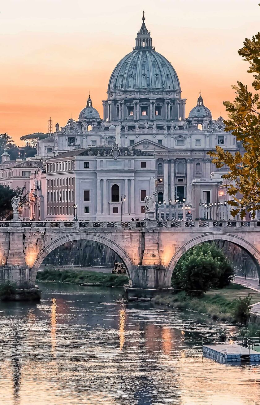Vista de Roma al atardecer con la cúpula de San Pedro y el río Tíber.