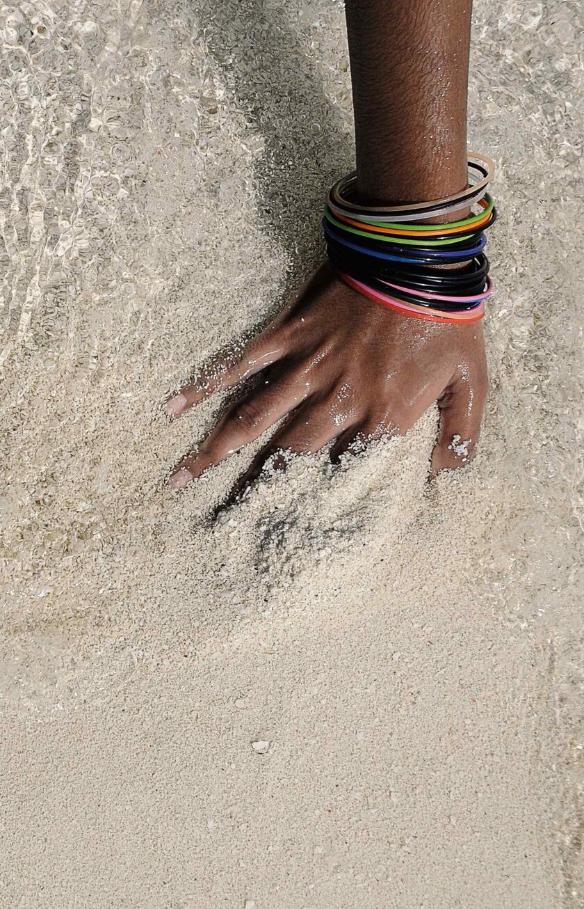 Mujer con su mano en el agua de las Maldivas