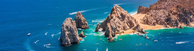 Vista aérea del mar y de una playa con rocas y arena dorada en Los Cabos, México