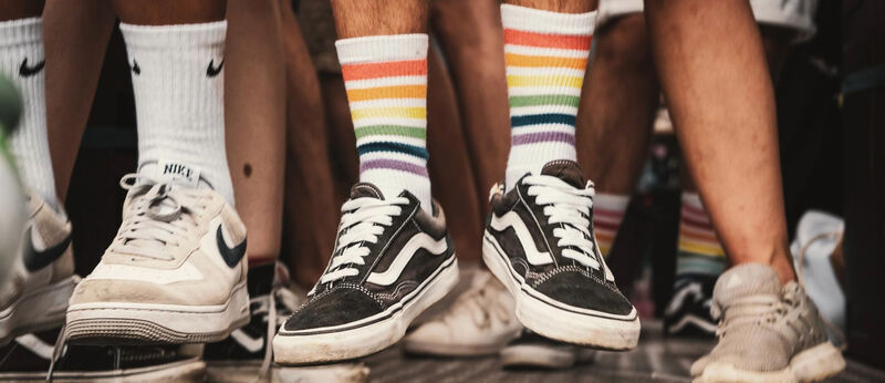pair of flying feet with vans and rainbow striped socks
