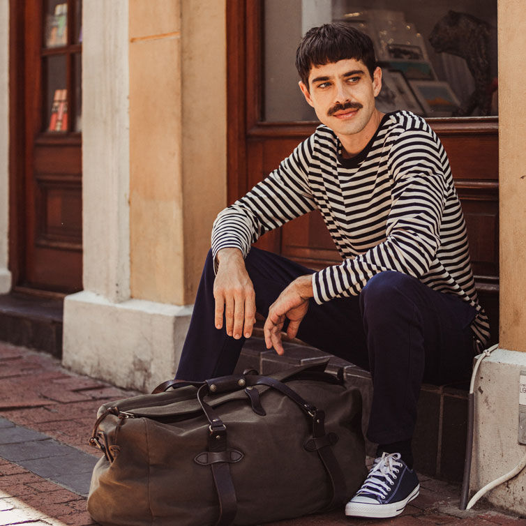 A man is waiting with his baggage for a train