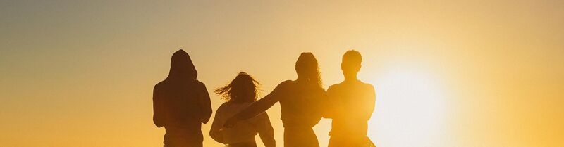 Four friends looking at the sunset in summer