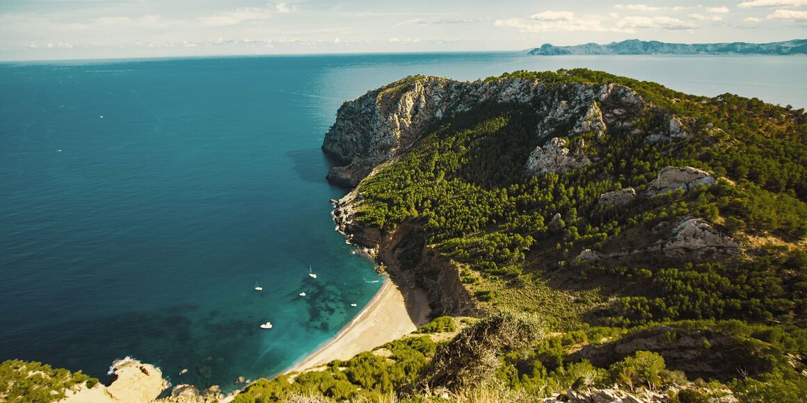 Aerial view of the cove Call Baix in Majorca, Spain, with a calm blue sea.