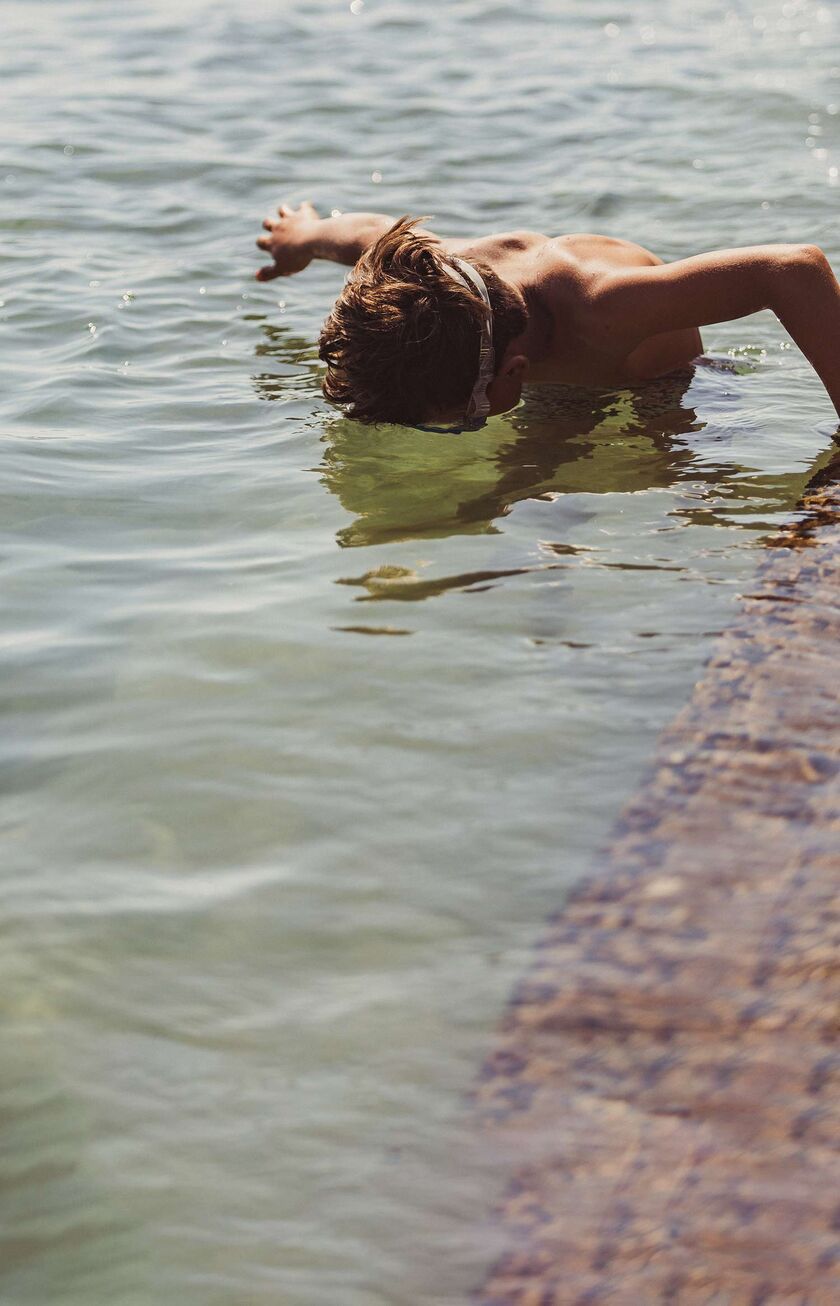 Boy snorkelling in the crystal clear waters of Corfu