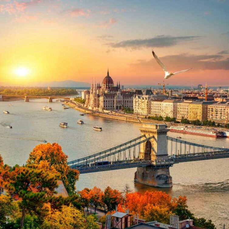 Aerial view of the bridge and river in Budapest with sunset in the background