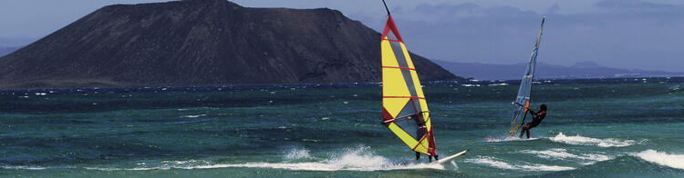 Planche à voile dans l'eau, montagne en arrière-plan