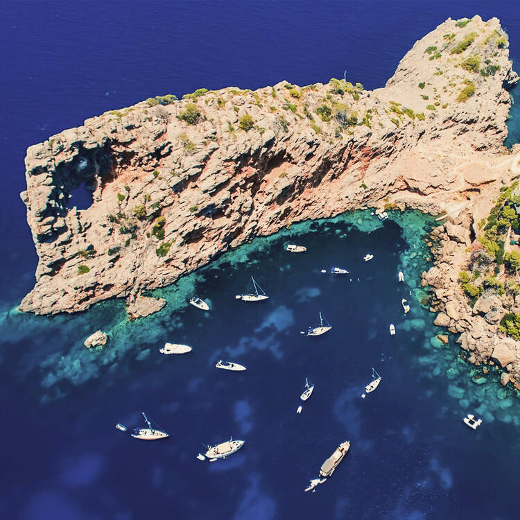 Vue aérienne d'une formation rocheuse dans la mer avec des bateaux blancs devant elle