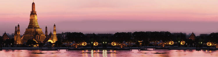  Vista panoramica del Wat Arun, Tempio dell'Alba, a Bangkok, con le luci del tramonto che si riflettono sul fiume Chao Phraya e un cielo rosato.