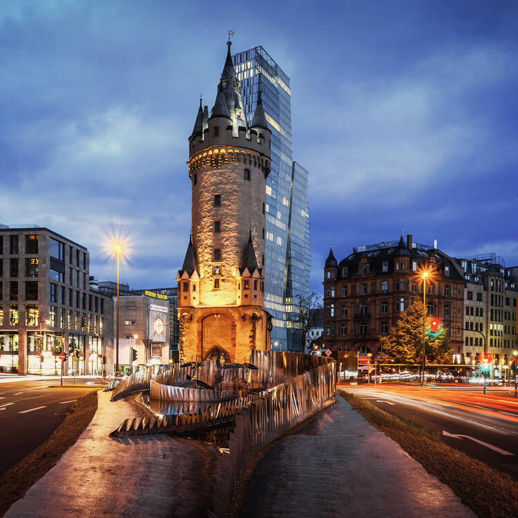 Torre di Eschenheim, edifici storici e moderni di Francoforte con la ferrovia leggera dopo il tramonto.