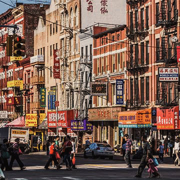 China Town New York City mit Einzelhandelsgeschäften und Menschen die auf dem Bürgersteig laufen