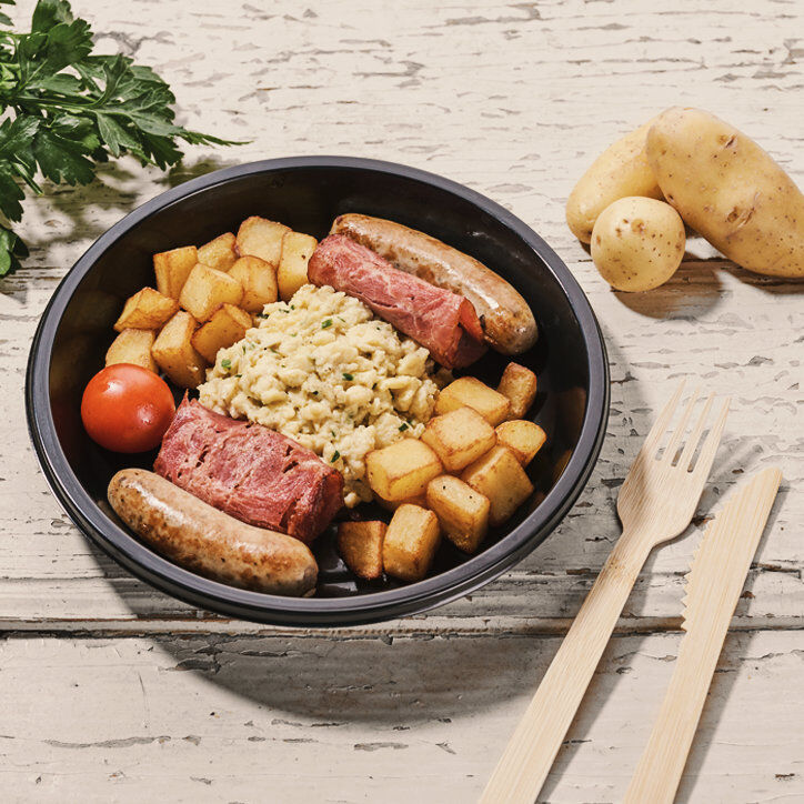 Roerei met pittige gebakken aardappelen, braadworstjes van varkensvlees, bacon en tomat