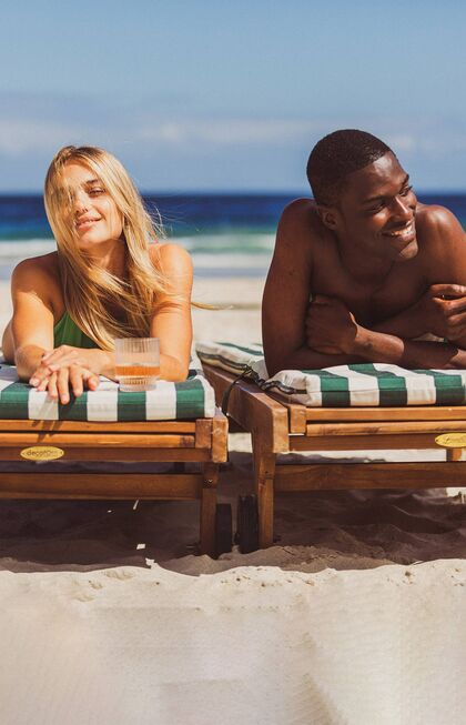 Ontspannen paar dat plezier heeft op het strand
