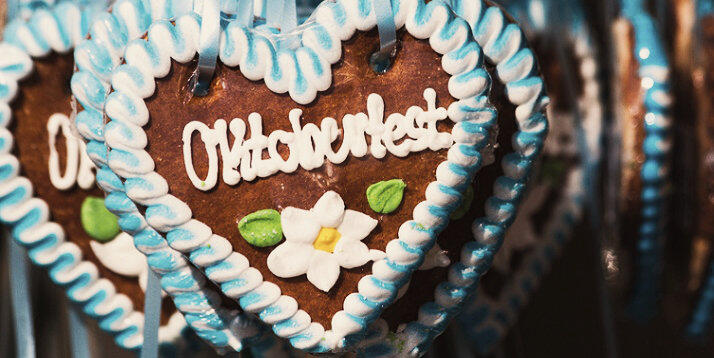 Tradicional biscoito de gengibre em forma de coração decorado com glacê branco e azul com a palavra 'Oktoberfest', pendurado como lembrança e símbolo do famoso festival de Munique