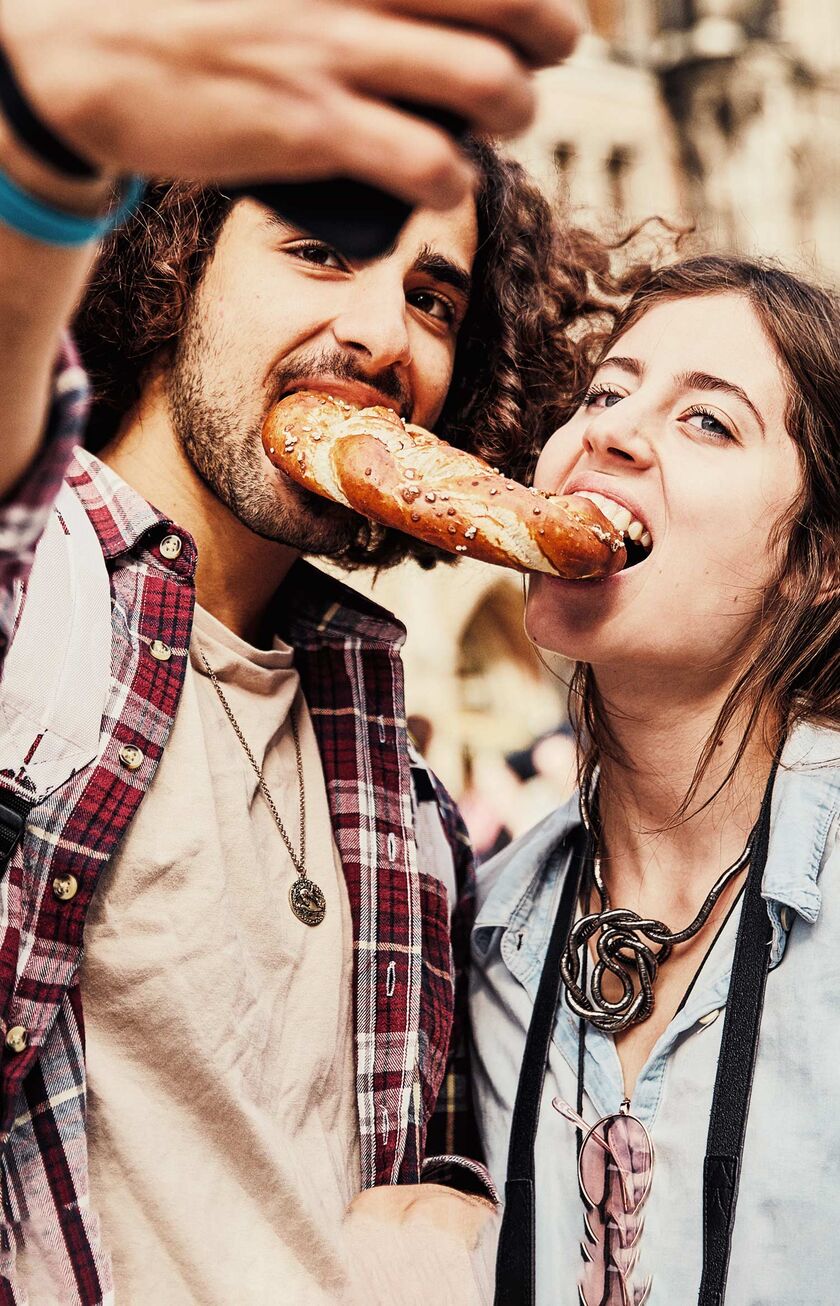 Couple sharing a pretzel at the Marienplatz in Munich.