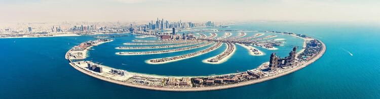 Vista aérea extensa da Palm Jumeirah em Dubai, mostrando as suas frondosas avenidas artificiais que se assemelham a uma palmeira