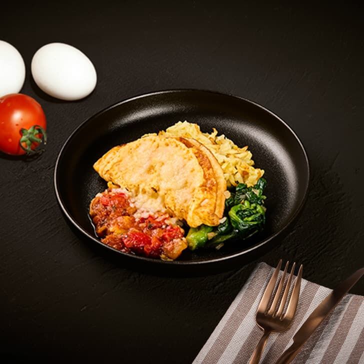 Omelete com recheio de queijo creme, tiras assadas, legumes com pimentão e flor de colza