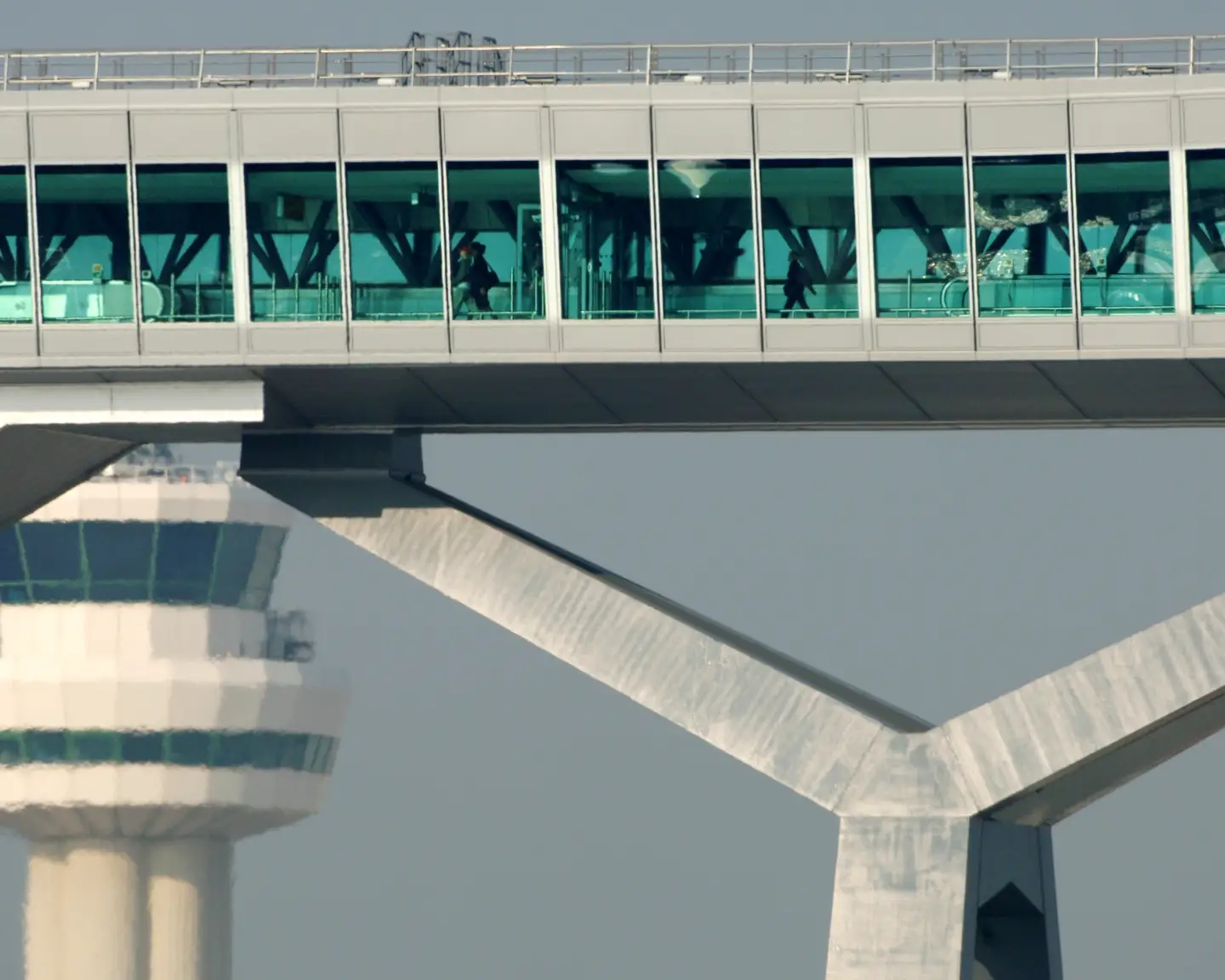 Gatwick Airport Pier 6 with a glass-enclosed passenger bridge and control tower in the background