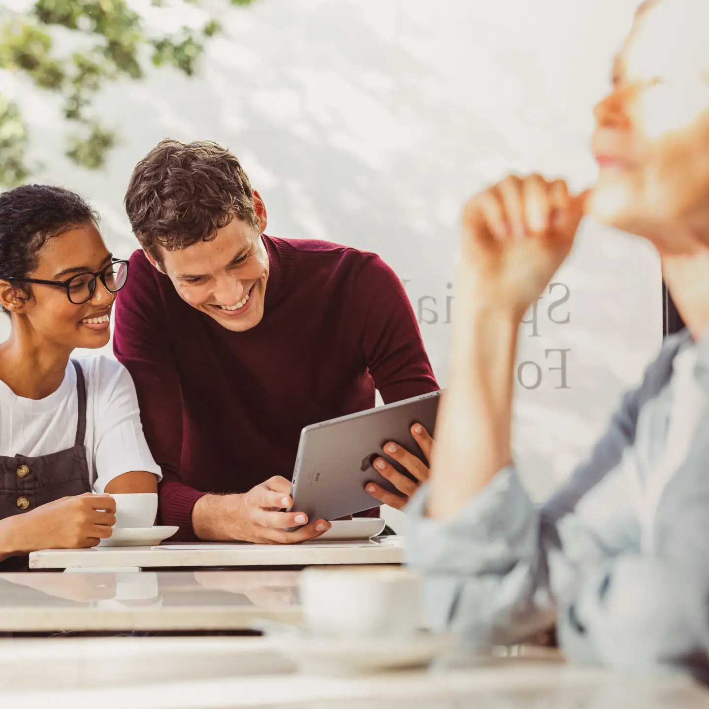 Two friends looking at a tablet together in the café
