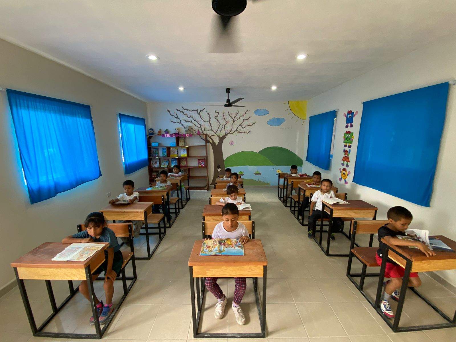 Varios niños están sentados en sus pupitres en un aula en México.