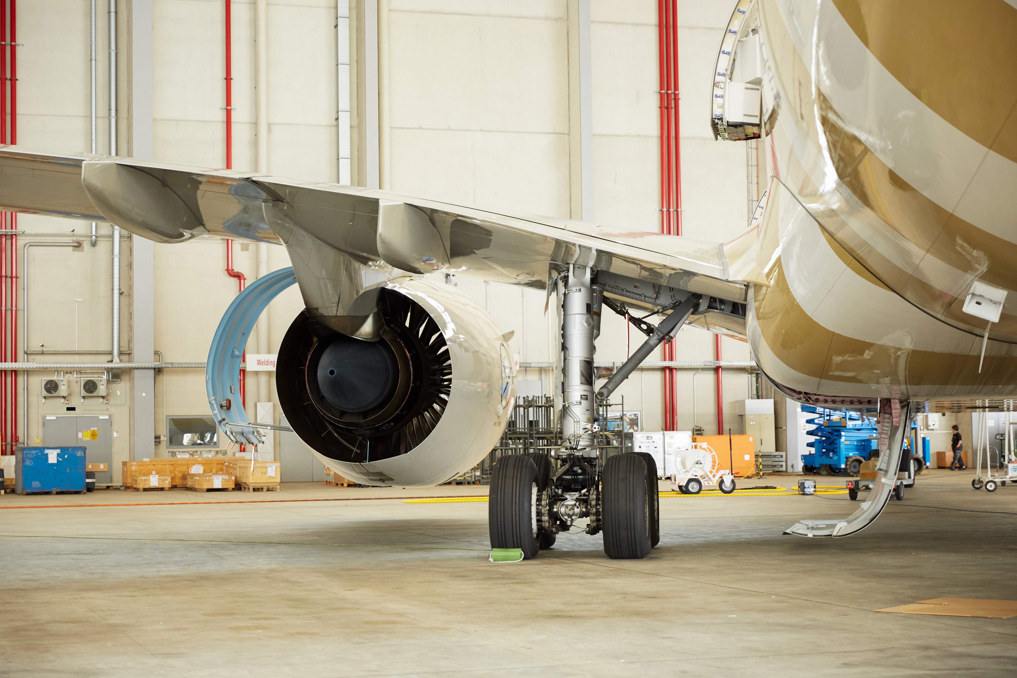 Primer plano de un motor de avión y tren de aterrizaje en un hangar durante el trabajo de mantenimiento rutinario de la aeronave.
