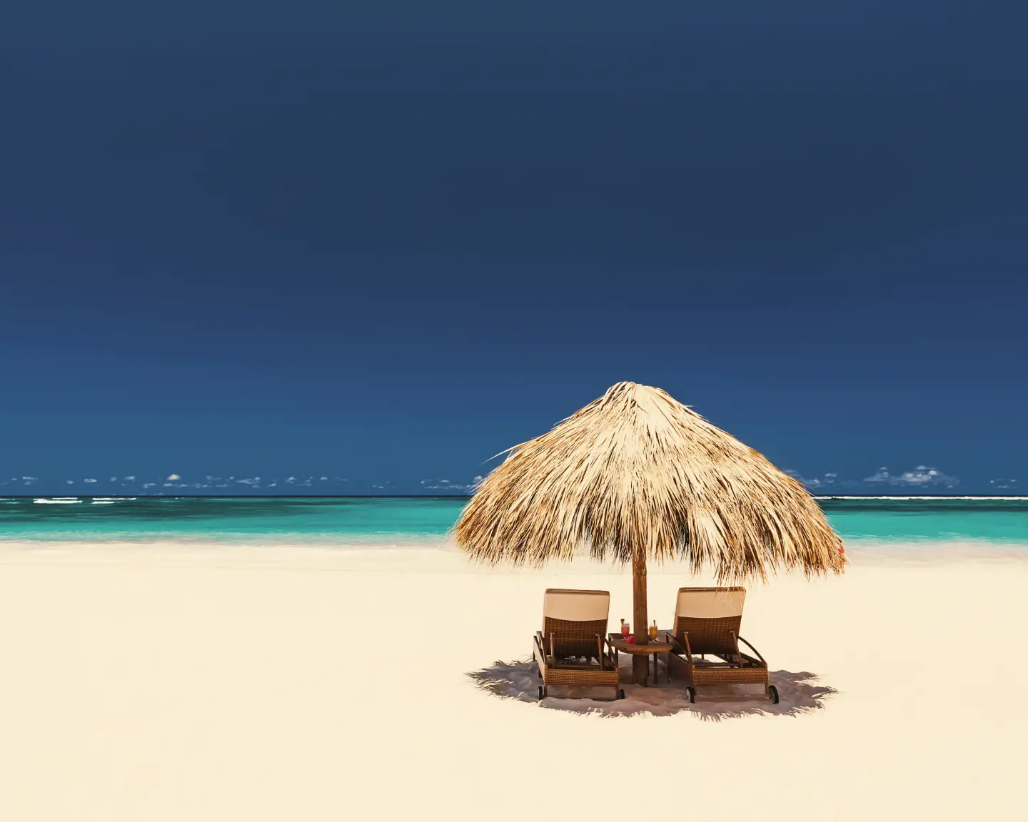 Tumbonas con sombrillas y una hermosa playa de arena en Punta Cana, República Dominicana