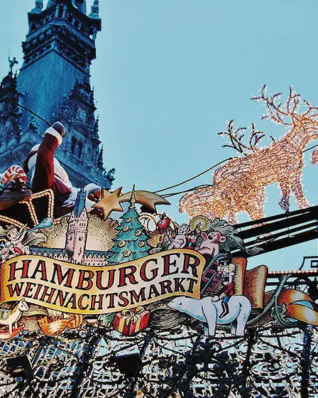 Un cartel luminoso sobre un acogedor puesto en el mercado navideño de Hamburgo
