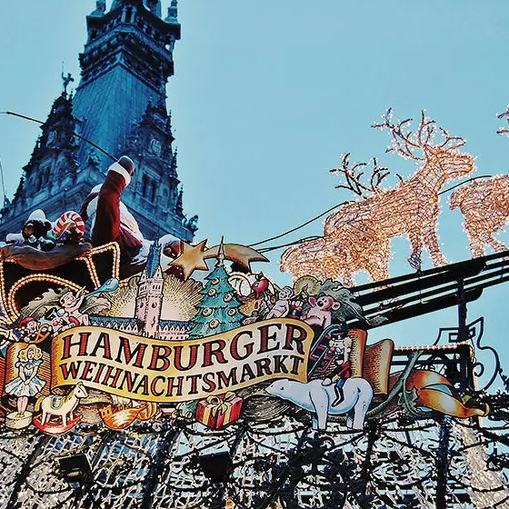 Un cartel luminoso sobre un acogedor puesto en el mercado navideño de Hamburgo