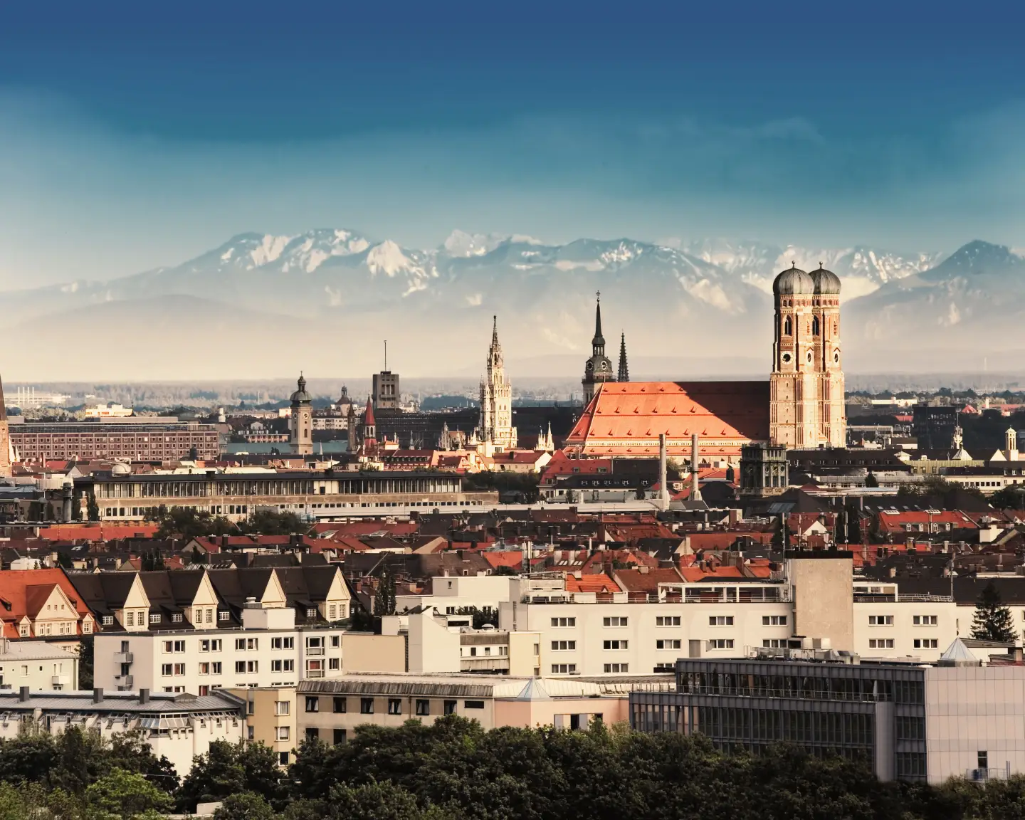 View over Munich with the Frauenkirche and the Alps in the background.