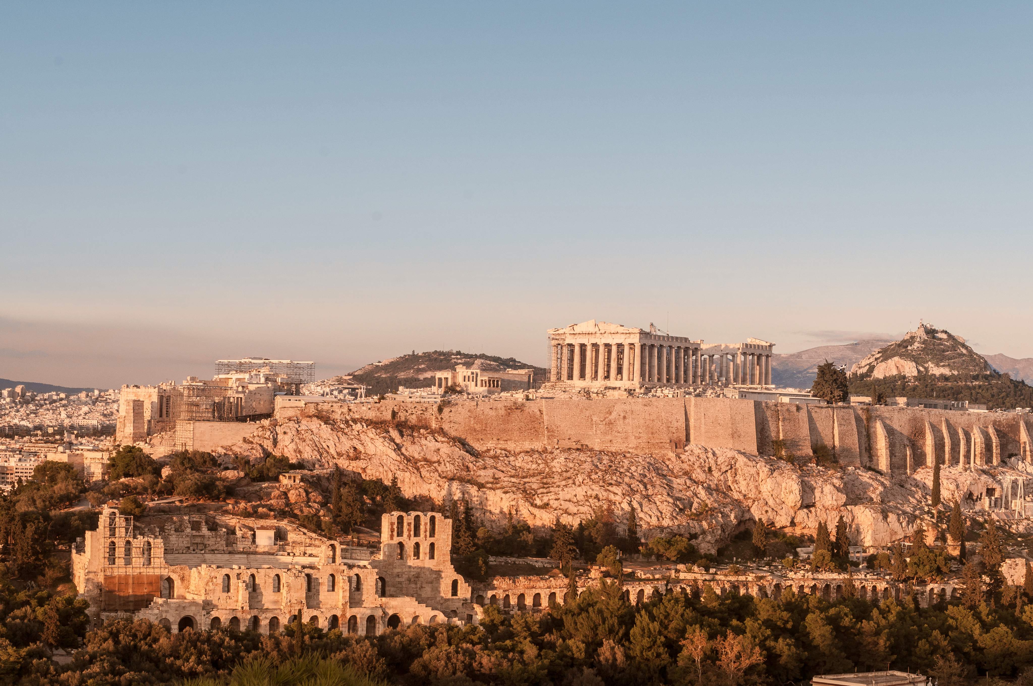 Panoramablick auf die Akropolis von Athen mit dem Parthenon und dem antiken Theater des Dionysos bei warmem Abendlicht in Griechenland.