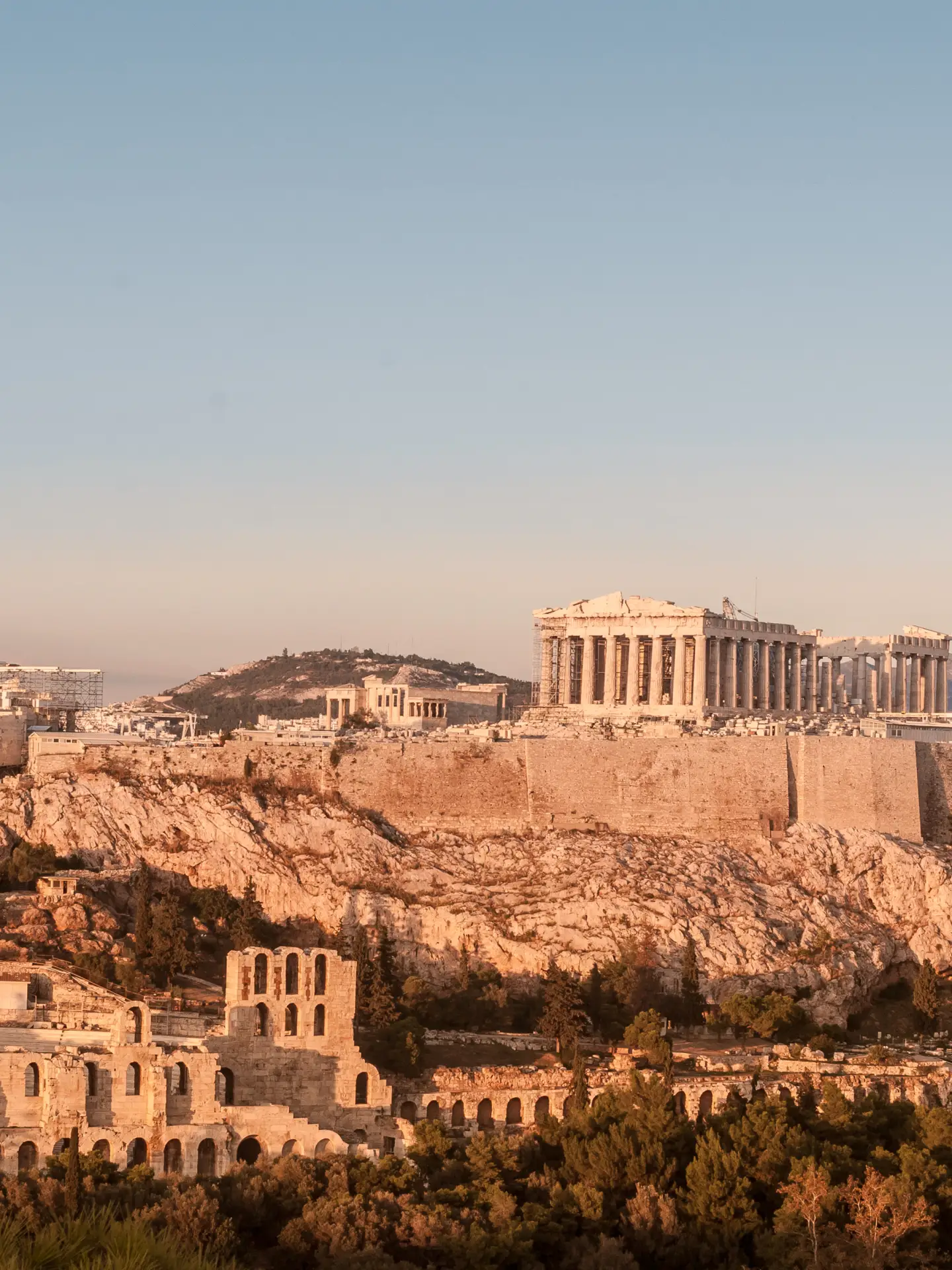 Panoramablick auf die Akropolis von Athen mit dem Parthenon und dem antiken Theater des Dionysos bei warmem Abendlicht in Griechenland.