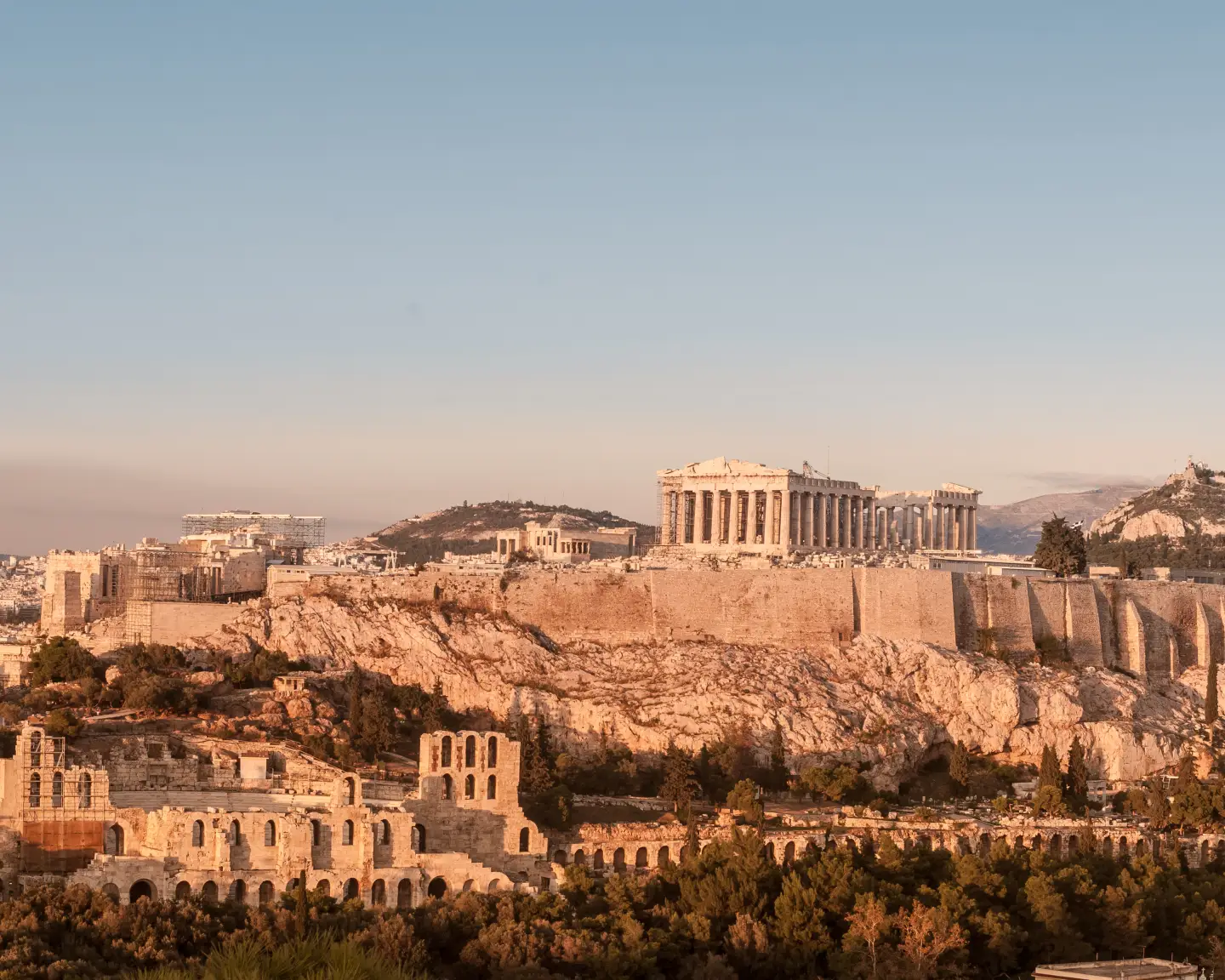 Vue panoramique sur l'Acropole d'Athènes avec le Parthénon et le théâtre antique de Dionysos sous une lumière chaude de soirée en Grèce.