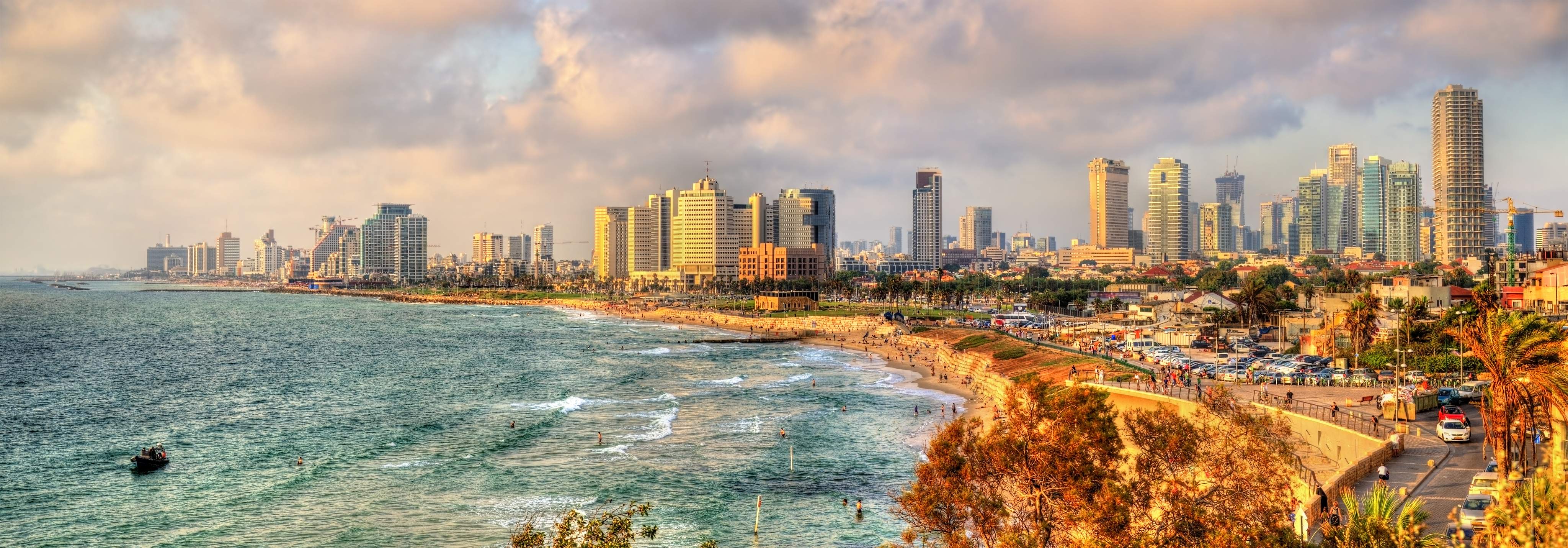 Beach promenade in Tel Aviv with sunset und skyline