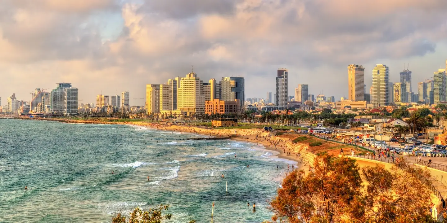 Beach promenade in Tel Aviv with sunset und skyline