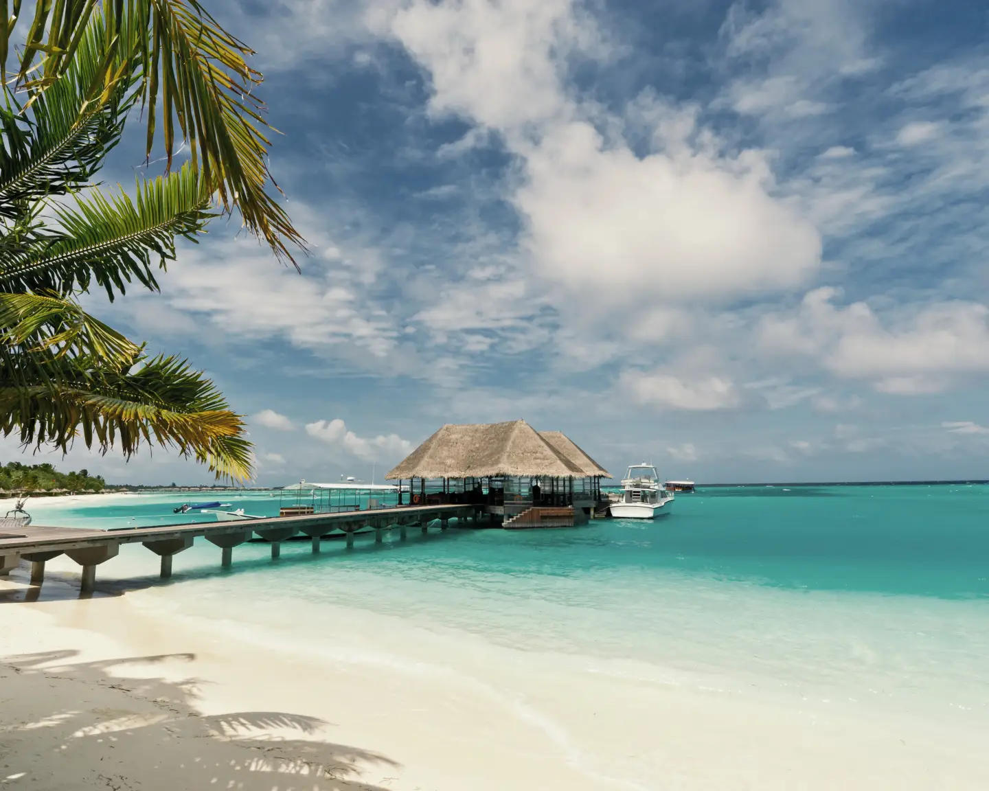 A footbridge connecting with the thatched jetty in maldives island resort