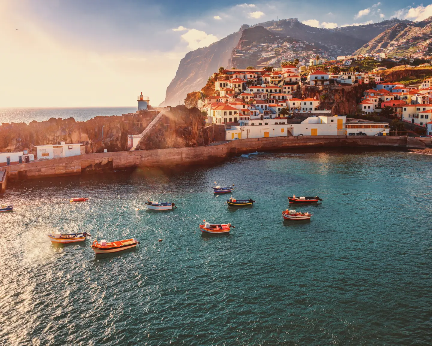Pohled z ptačí perspektivy na rybářskou vesnici Camara de Lobos na portugalském ostrově Madeira v teplém světle večerního slunce.