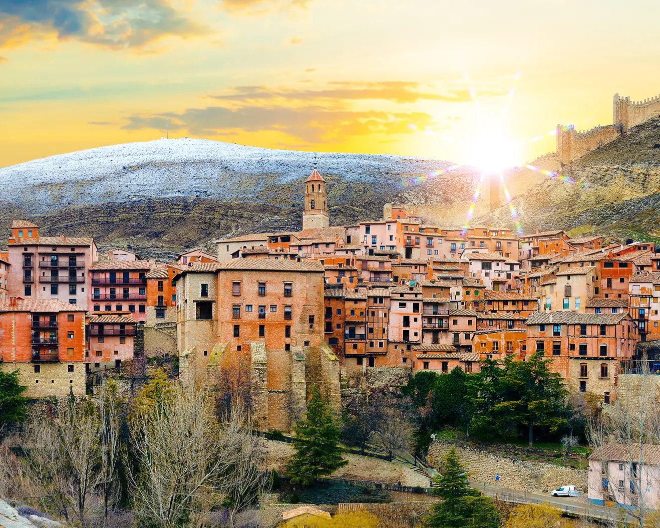 Panoramablick auf die mittelalterliche Altstadt von Albarracín mit historischen Häusern, Kirchen und der Stadtmauer bei Sonnenuntergang.