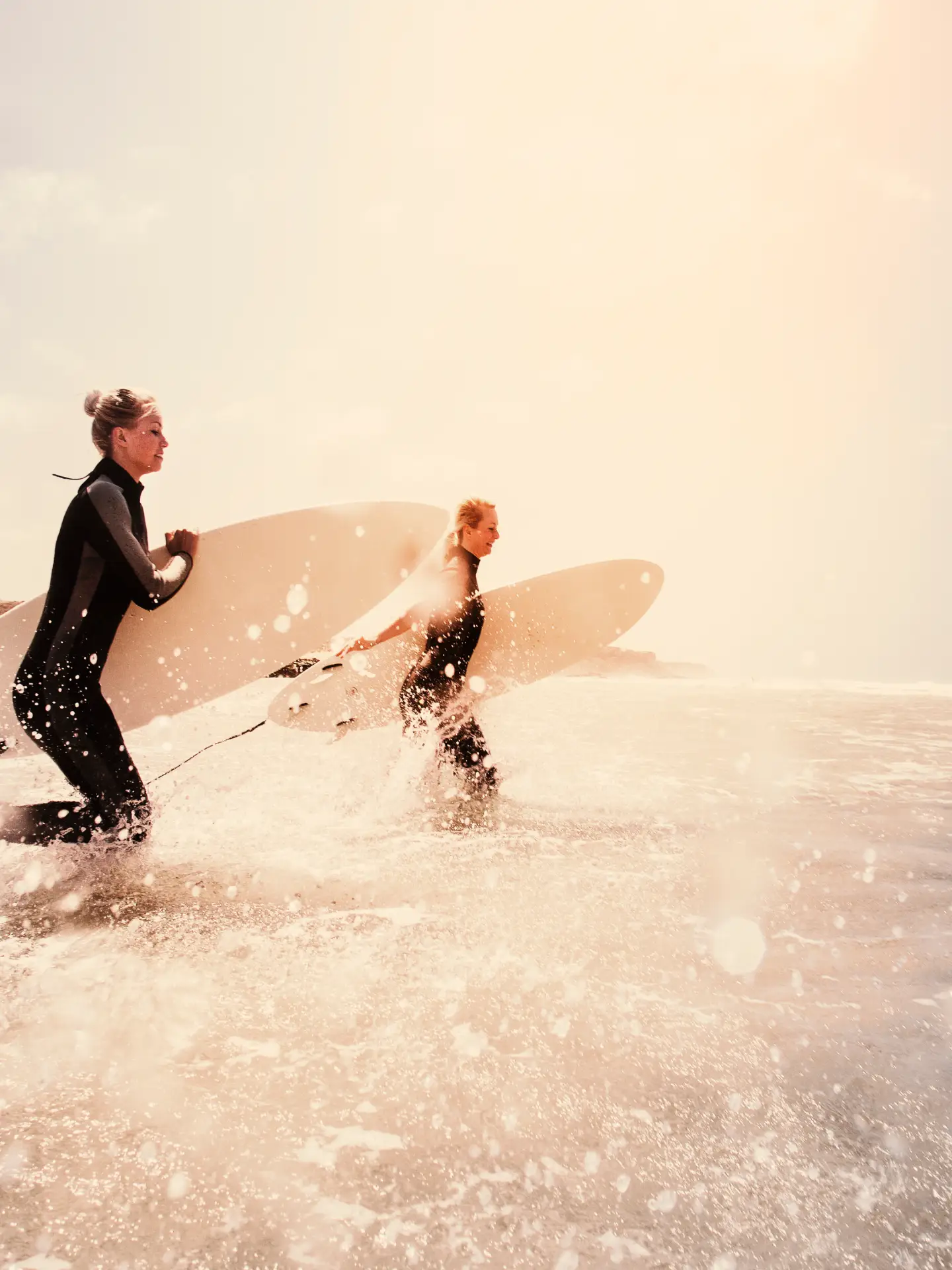 Two people are holding a surfboard in the sea