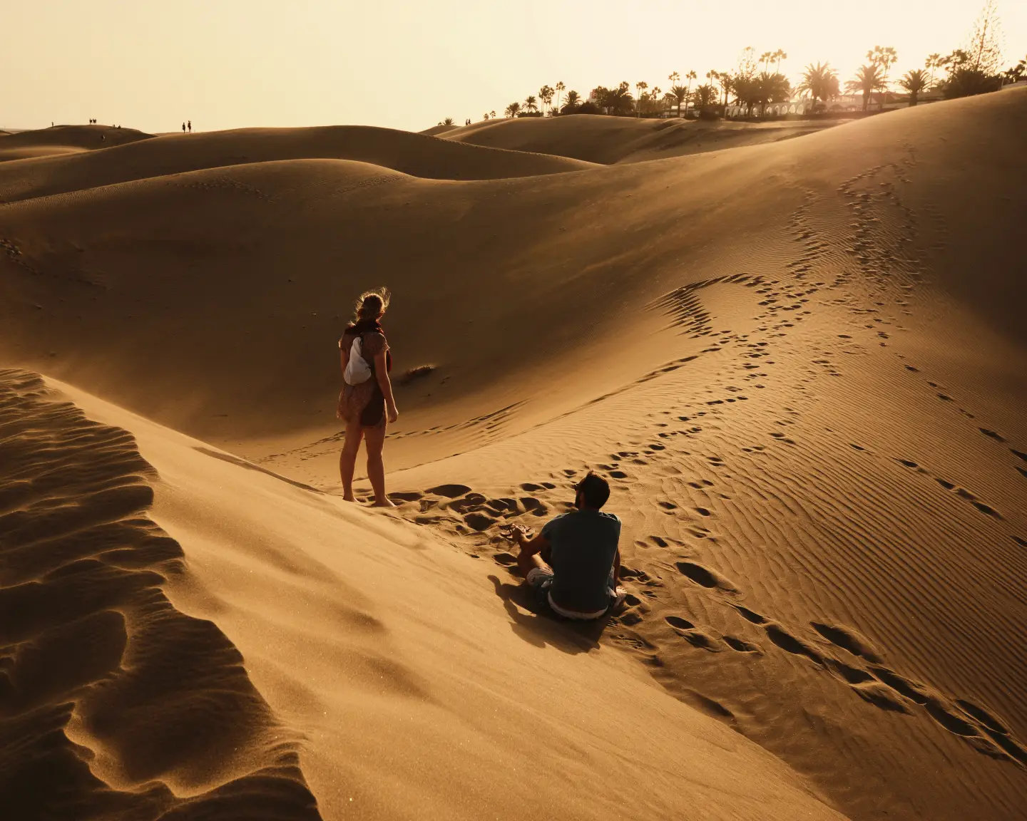 Sandige Küste von Gran Canaria mit Menschen auf den Sandhügeln.