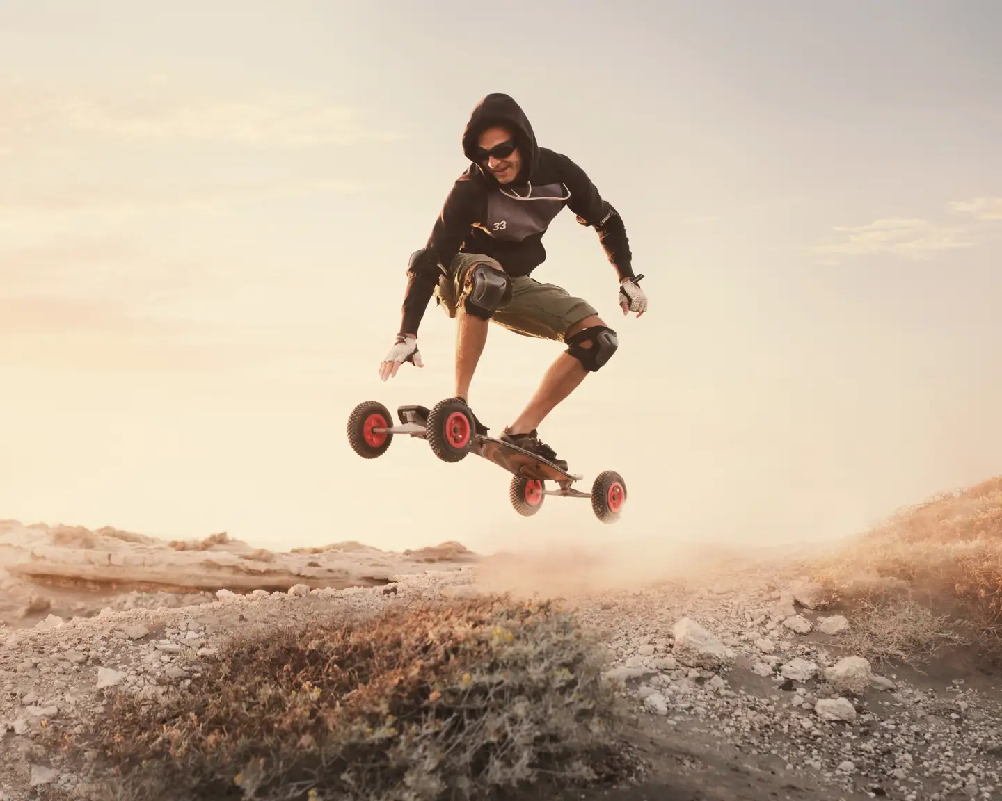 Un skater hace una pirueta delante del sol poniente.