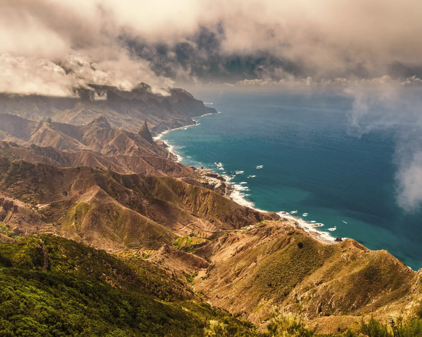 Luftaufnahme der Anaga-Küste in Teneriffa, mit dramatischen Bergen und einem tiefblauen See.