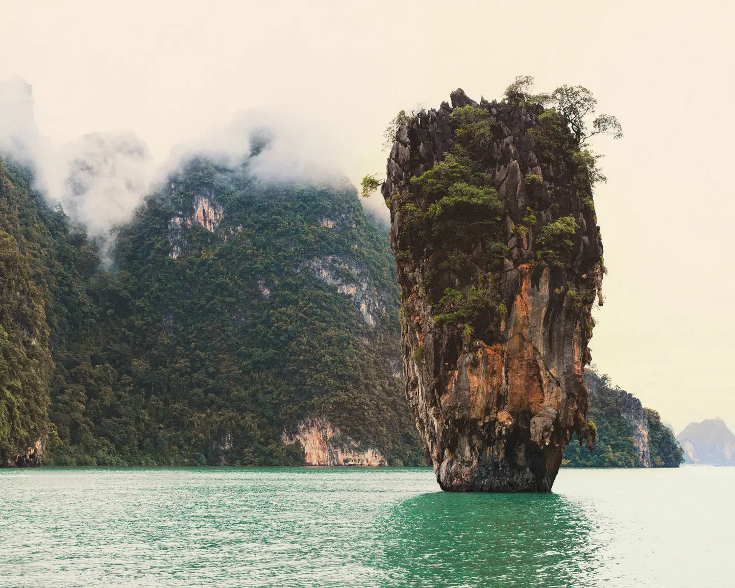 Un espectacular acantilado de piedra caliza, conocido como James Bond Island, se eleva majestuoso desde las aguas de color verde esmeralda de la bahía de Phang Nga, en Tailandia.