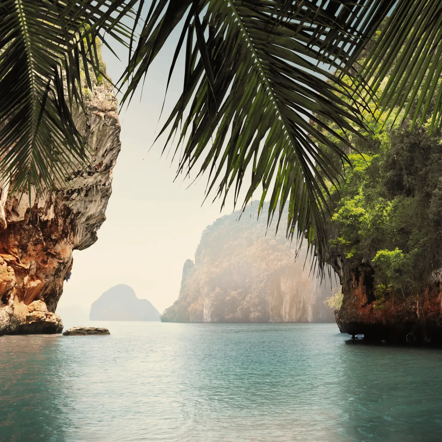 The breathtaking bay of Khao Phing Kan, Thailand, surrounded by high limestone cliffs and lush vegetation.