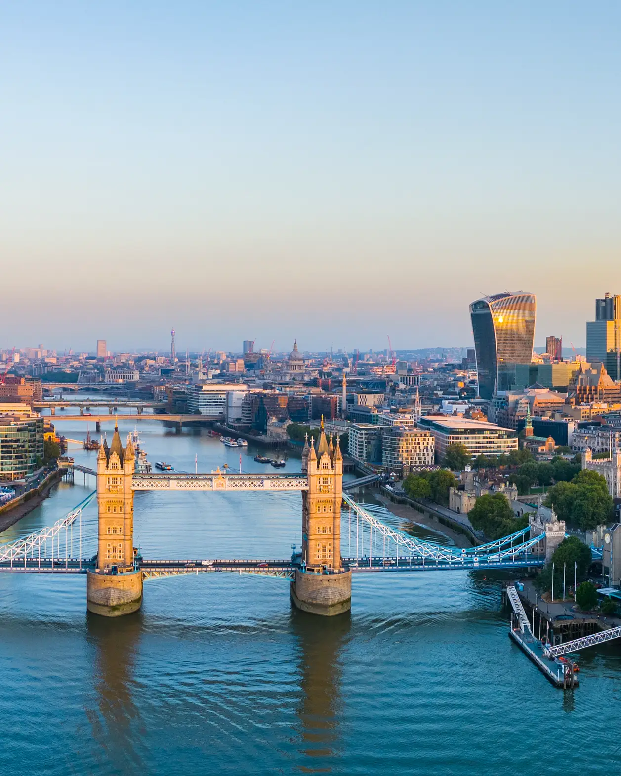 Panoramic view of Tower Bridge, the River Thames and the modern skyline of the City of London with the Shard and the financial district in the evening light.