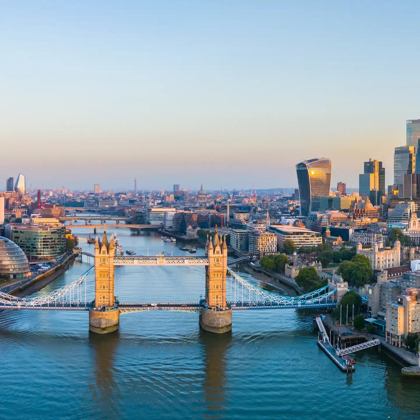 Panoramic view of Tower Bridge, the River Thames and the modern skyline of the City of London with the Shard and the financial district in the evening light.