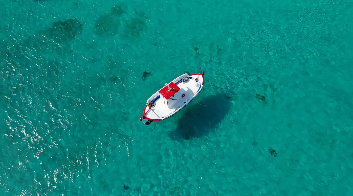 Türkisblaues Meer mit Boot aus der Vogelperspektive