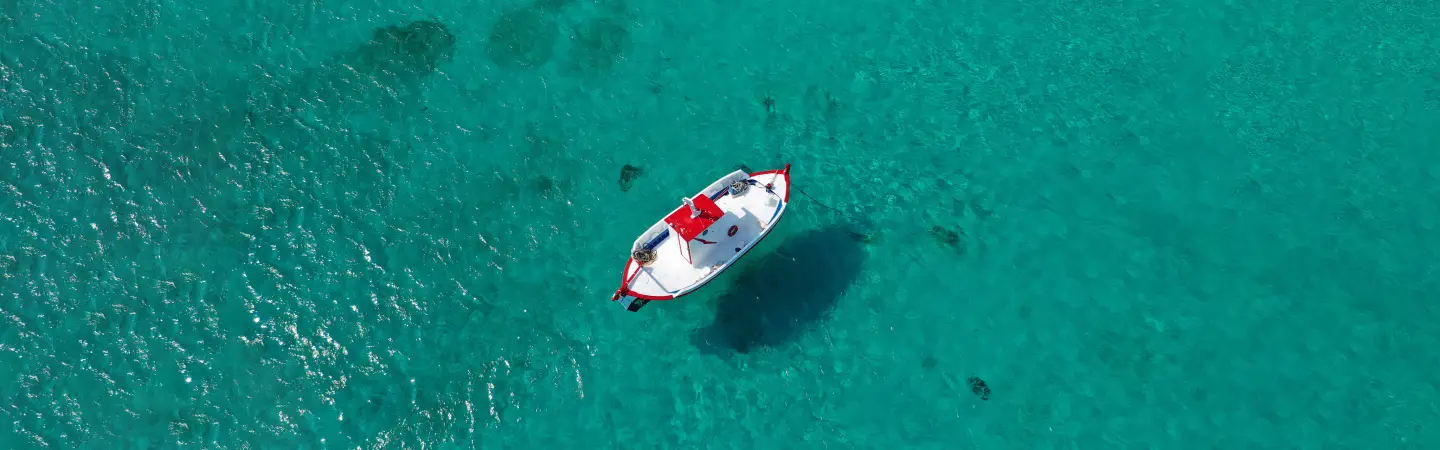 Türkisblaues Meer mit Boot aus der Vogelperspektive