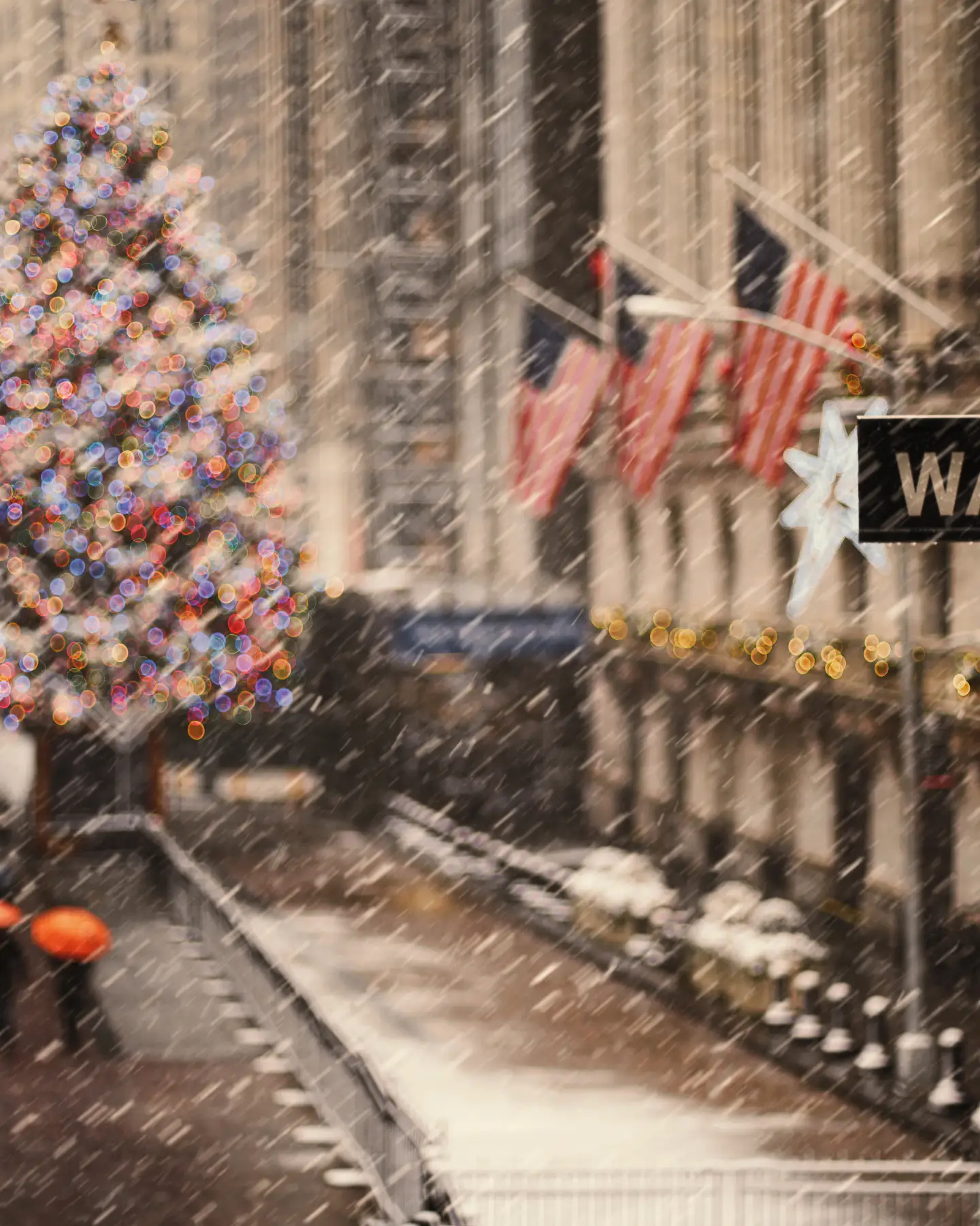 View of Wall Street in New York with a lit-up Christmas tree in the snow during the holiday season,
